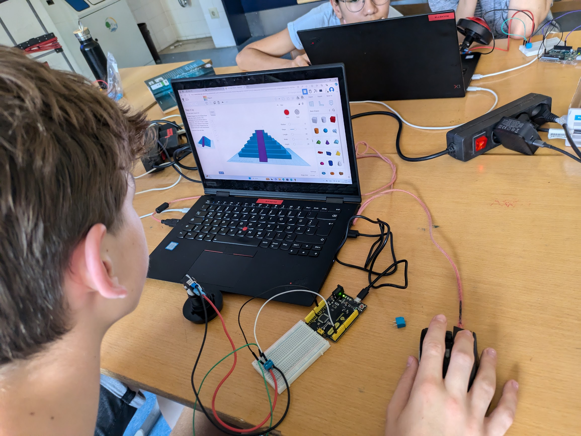 Schüler arbeitet mit TinkerCAD, um ein 3D-Modell für ein Steuerpult zu entwerfen.