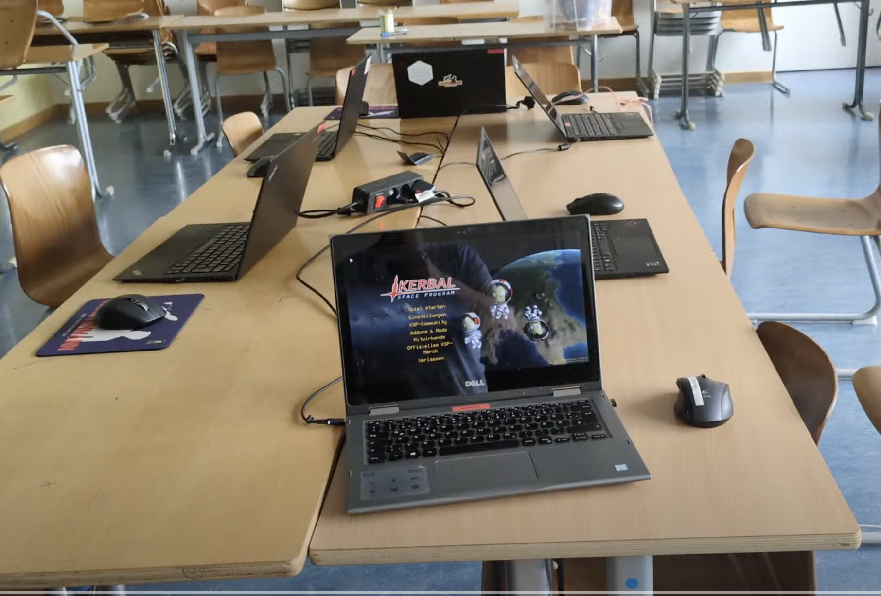 Klassenzimmer-Setup mit Laptops, einer zeigt das Hauptmenü des Kerbal Space Program.